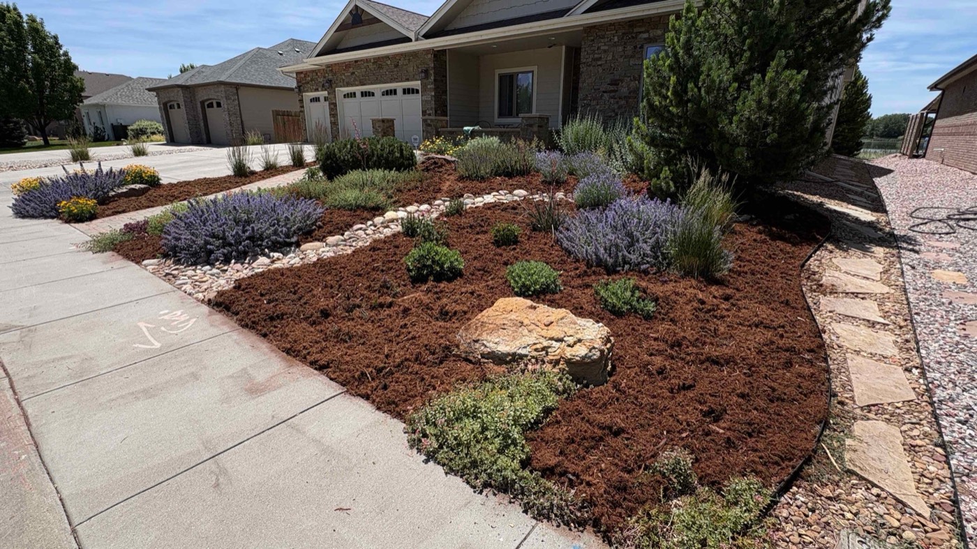 Front-yard mulch and river-rock bed with lavender, boulders, and shrubs